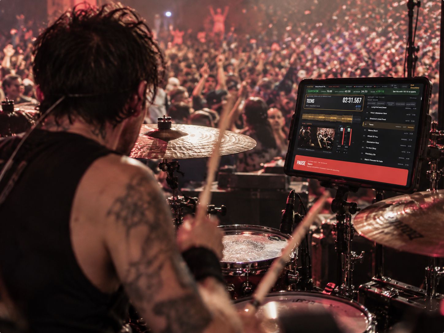 Illustration: a drummer on stage in front of a crowd, with the iPad on a stand beside the kit showing Showtime
